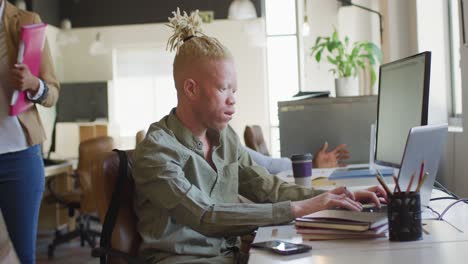 un homme d'affaires afro-américain albinos utilisant un ordinateur portable dans un bureau créatif