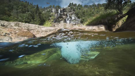 The-immersive-perspective-of-a-river-with-rocky-shores-and-pristine-waters