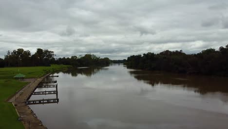 un hermoso río revela un tiro volando entre 2 árboles hacia el río vaal, estado libre, sudáfrica