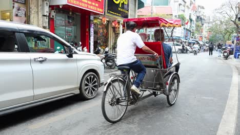 tourist enjoying cyclo ride in busy hanoi