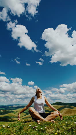 woman meditating outdoors under a blue sky with clouds