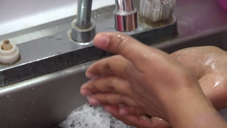 a person washing peppers in the sink