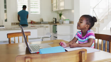 niña afroamericana dibujando durante la escuela en línea en casa