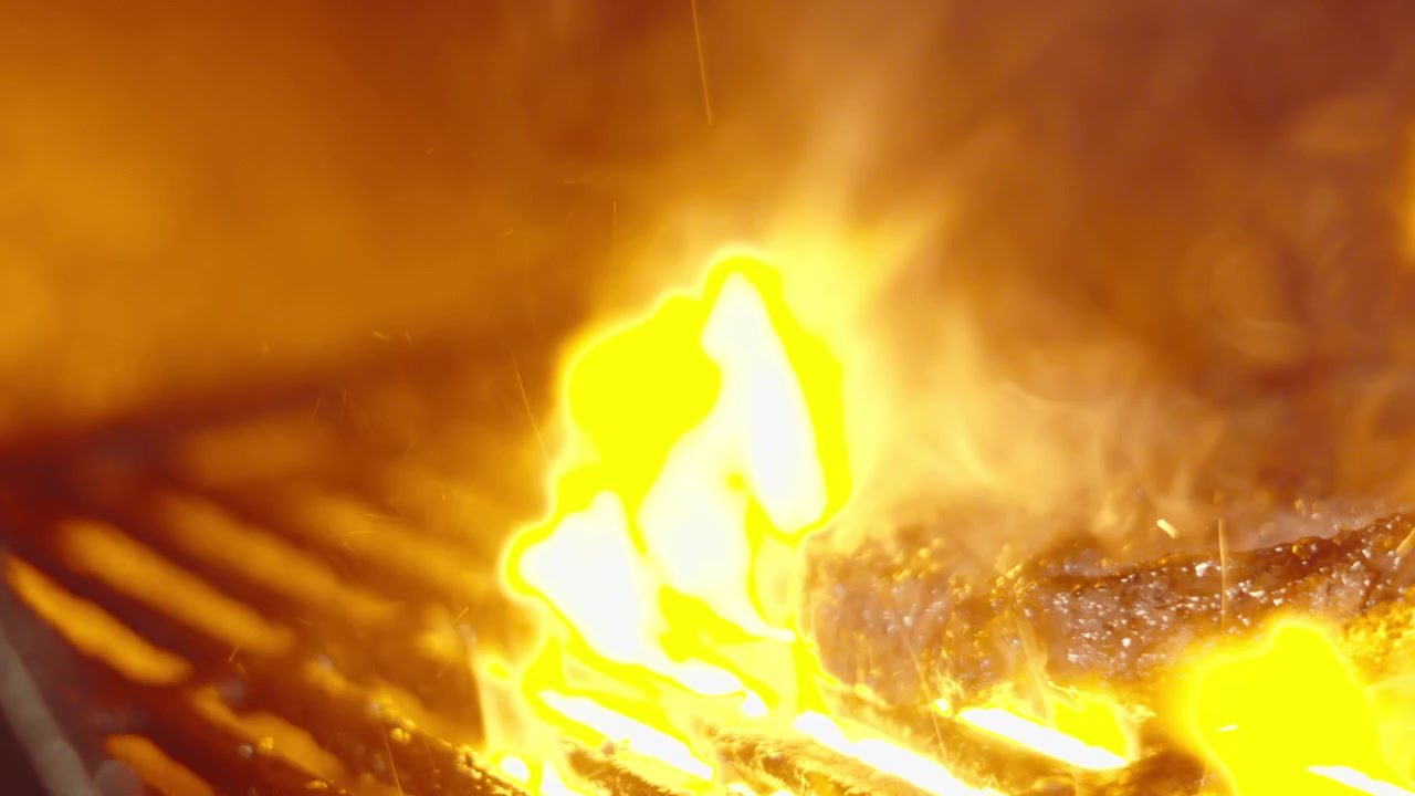 Chef che gira delicatamente una bistecca sul barbecue con fiamme che erompono dal basso