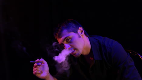 man smoking in dark lighting