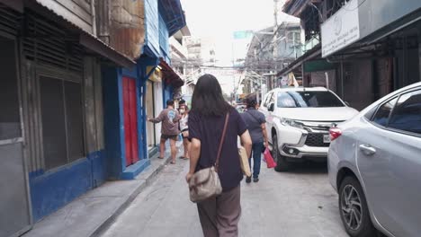 Tracking-rearview-shot-of-unrecognizable-woman-walking-through-empty-street