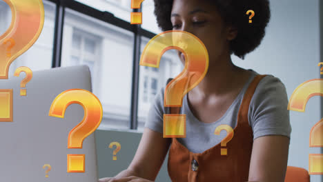animación de signos de interrogación sobre una mujer de negocios afroamericana usando una computadora portátil