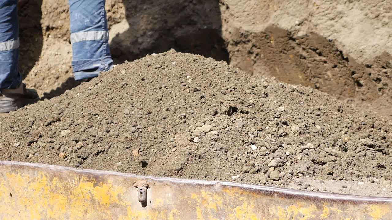 trabajador de la construcción limpiando la tierra