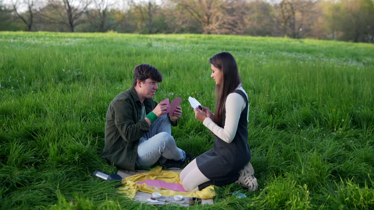 Couple Playing Cards in a Park