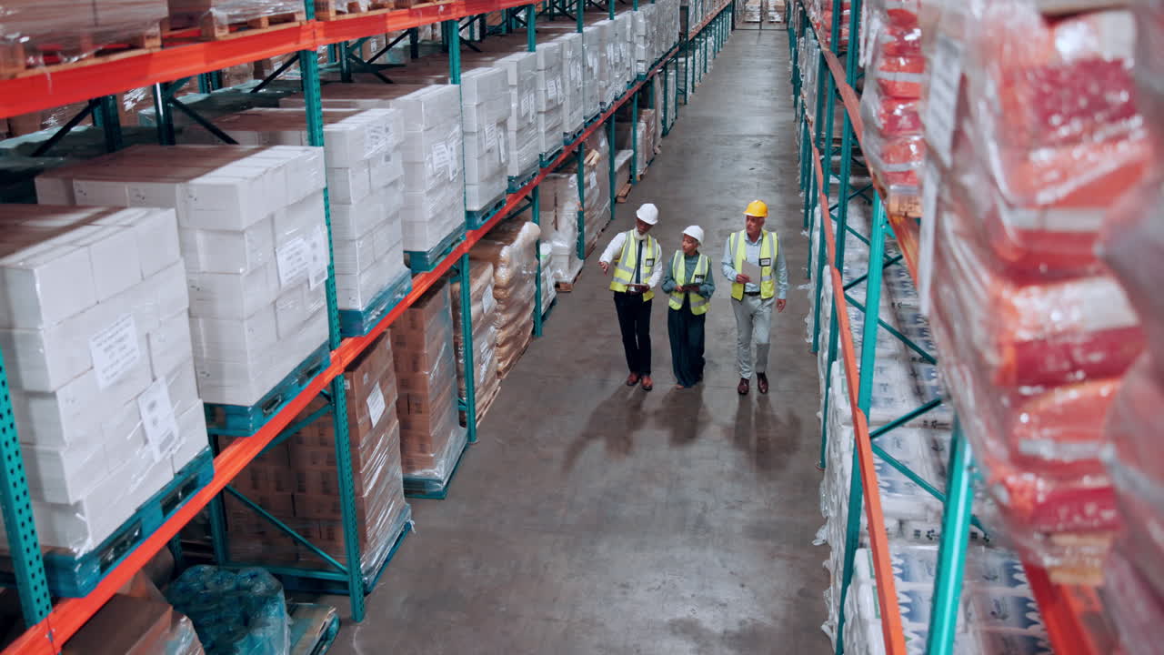 Logistics Team Walking and Discussing in a Large Warehouse