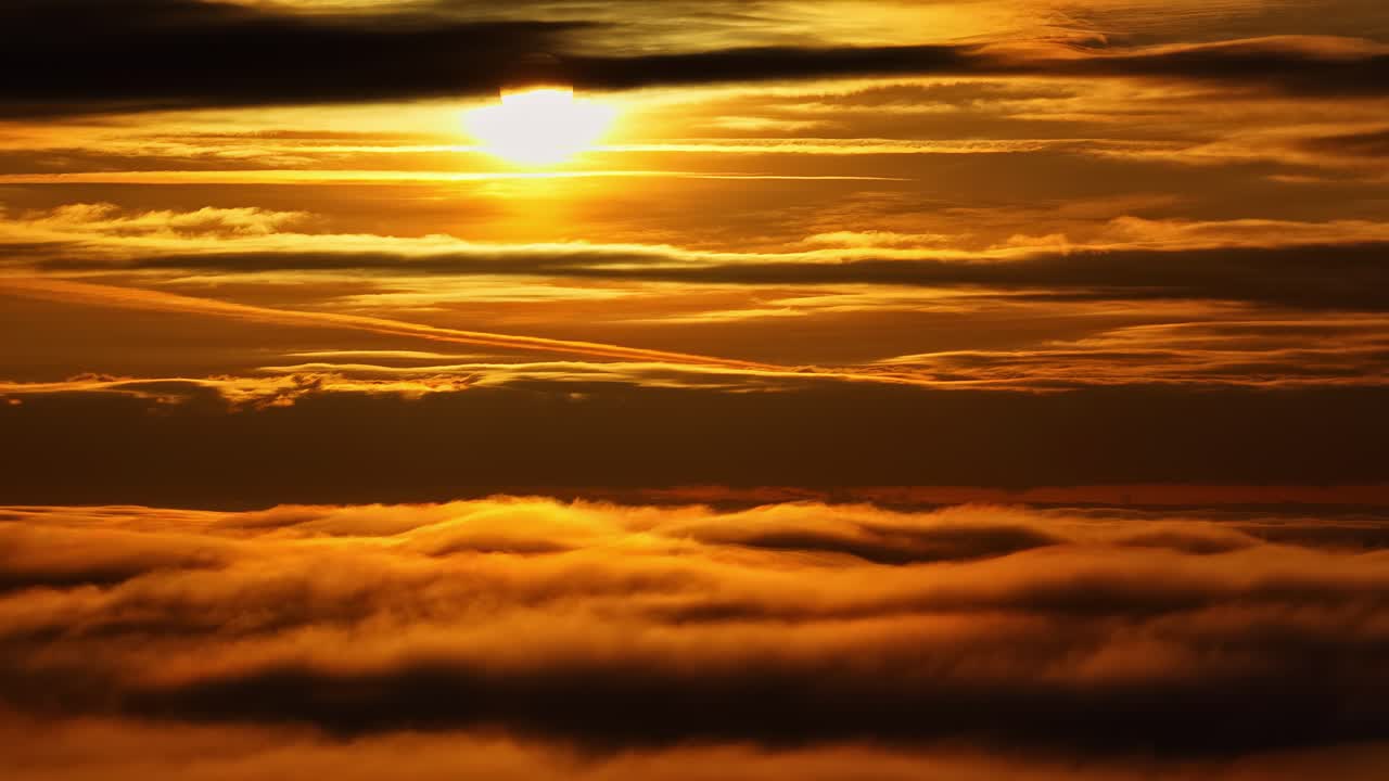 Um belo pôr do sol visto de cima da inversão das nuvens, com o sol atrás do nascer do sol
