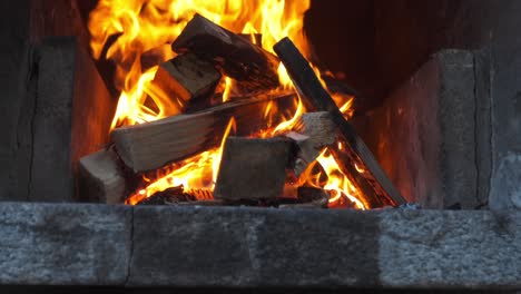flames burning in a fireplace with wooden logs and glowing orange fire