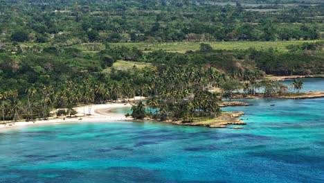 Aerial-establishing-overview-of-turquoise-clear-blue-water-and-tropical-coastline-of-Samana-bay-Dominican-Republic