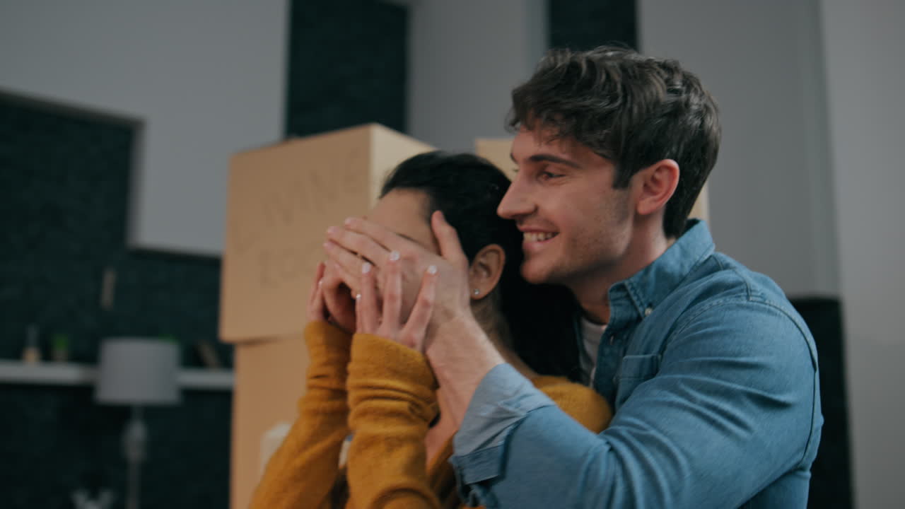 hombre haciendo sorpresa esposa entrando en nueva casa. sorprendido esposa sonriendo abrazando tipo.