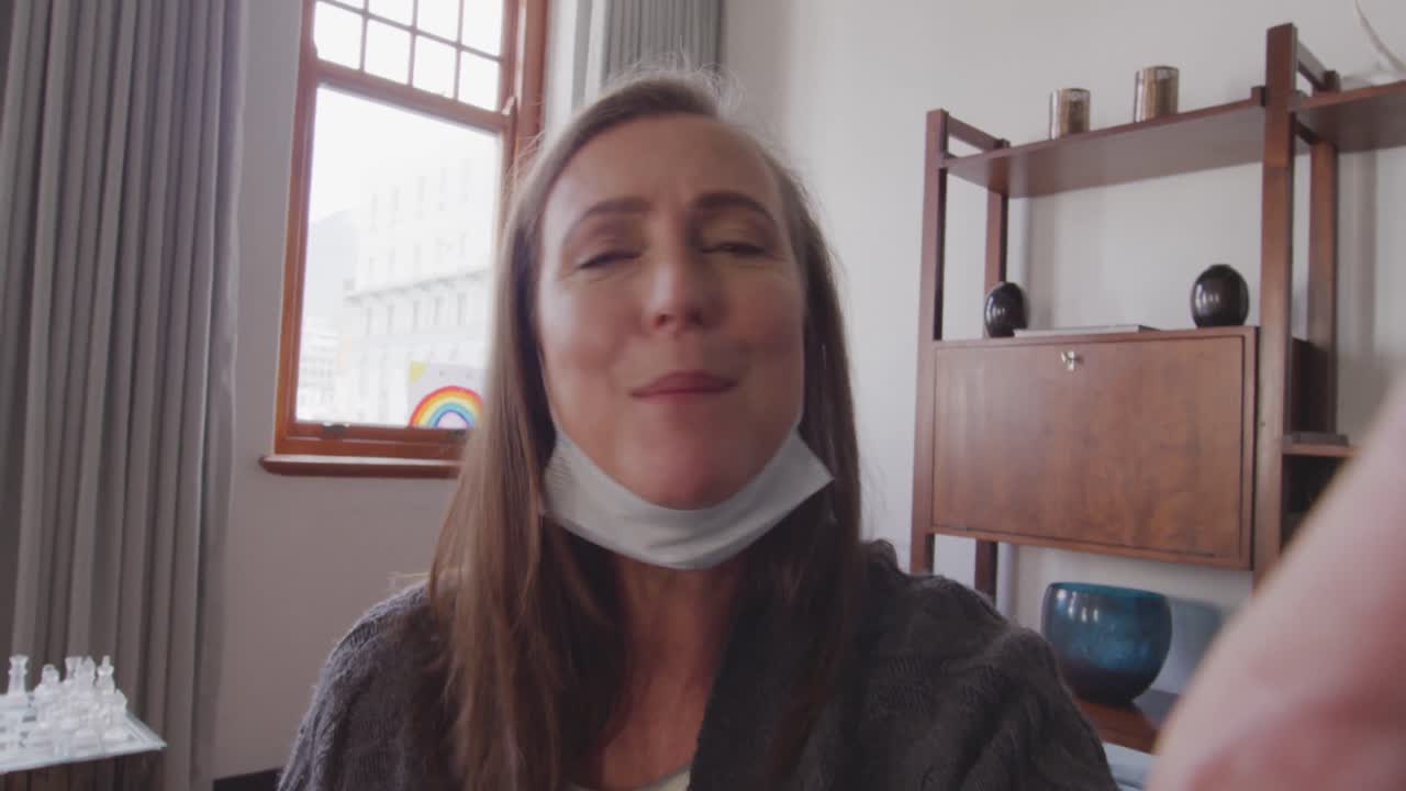 mujer teniendo un video chat en su teléfono inteligente en casa