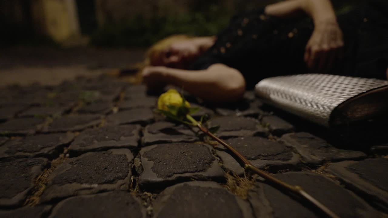 dead woman on the street - yellow flower on the ground with her wallet