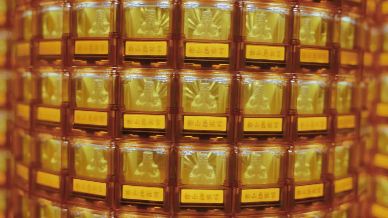 Close-up of many golden Buddha statues glowing in illuminated niches at Ciyou Temple in Taiwan, symbolizing devotion, peace, and spiritual reverence in a sacred Buddhist space