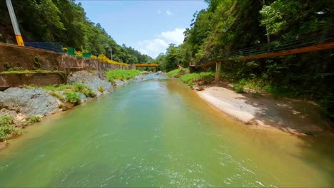 Drone-De-Carreras-Volando-Bajo-El-Puente-Sobre-El-Río-Jimenoa-En-Jarabacoa,-República-Dominicana