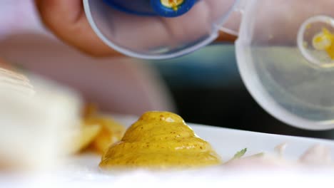 close up of a dollop of yellow mustard on a plate