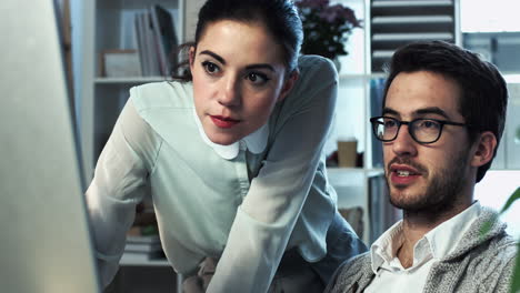 pareja joven atractiva trabajando en la computadora tarde en la noche en casa