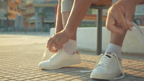 mature couple lacing running shoes before jog