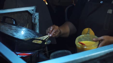 Womens-hands-frying-food-named-egg-roll