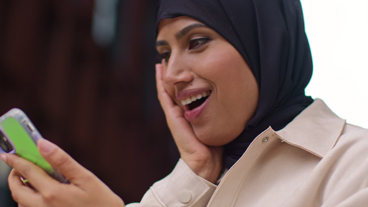 Muslim Businesswoman Wearing Hijab Standing Outside Modern Office Getting Good News About Job Offer Or Promotion On Mobile Phone 1