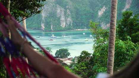 fotografía de una persona balanceándose en una hamaca, mirando la costa de las islas phi phi