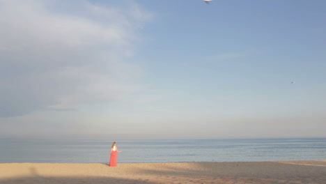 girl in orange dress says good bye to the sea and walking away