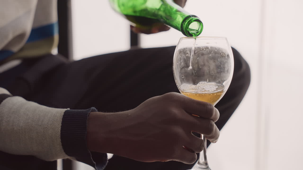 Homem servindo vinho em ambiente aconchegante. Close-up de homem servindo vinho suavemente em ambiente interno acolhedor. Uma cena íntima mostrando homem servindo vinho em ambiente interno aconchegante com iluminação suave da janela