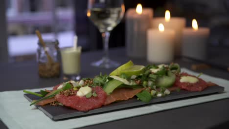 Plato-De-Carpaccio-Servido-Con-Queso,-Verduras-Y-Pomelo-En-Un-Elegante-Restaurante