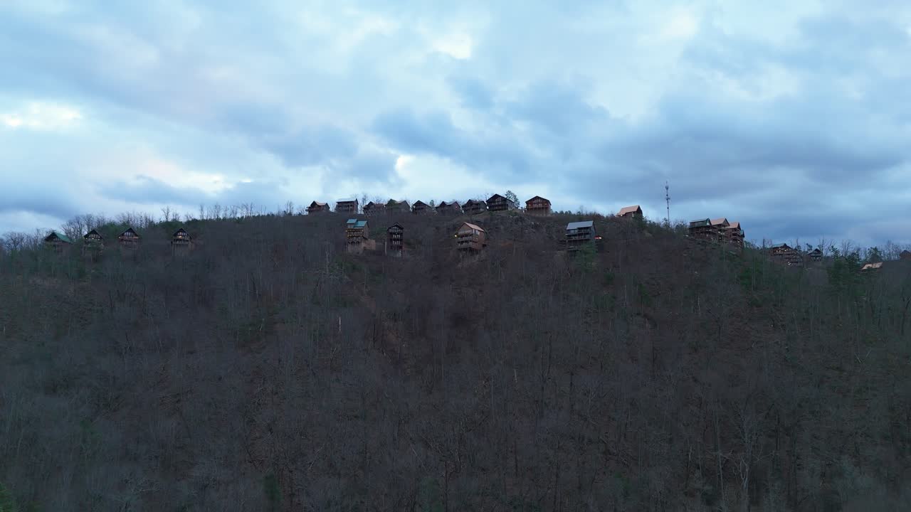 Aerial shot pushing in on cabins at the top of a mountain outside of Gatlinburg, TN.