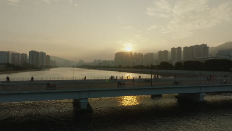 홍콩의 서넷 (hong kong at surnet) 은 초고층 빌딩, 시내 풍경, 보행자가 있는 현대적인 건물, 중국인들이 황금 시간대에 다리를 고 있는 모습이다.