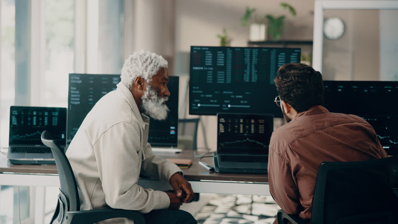 Two finance professionals discussing stock market trends in an office environment