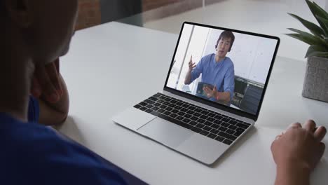 Mid-section-of-african-american-woman-having-a-video-call-with-male-colleague-on-laptop-at-office