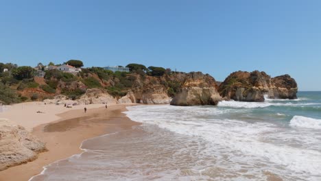 Las-Olas-Del-Océano-Chocan-Y-Se-Extienden-Por-La-Playa-De-Arena-Dorada-En-Cámara-Lenta,-Aérea