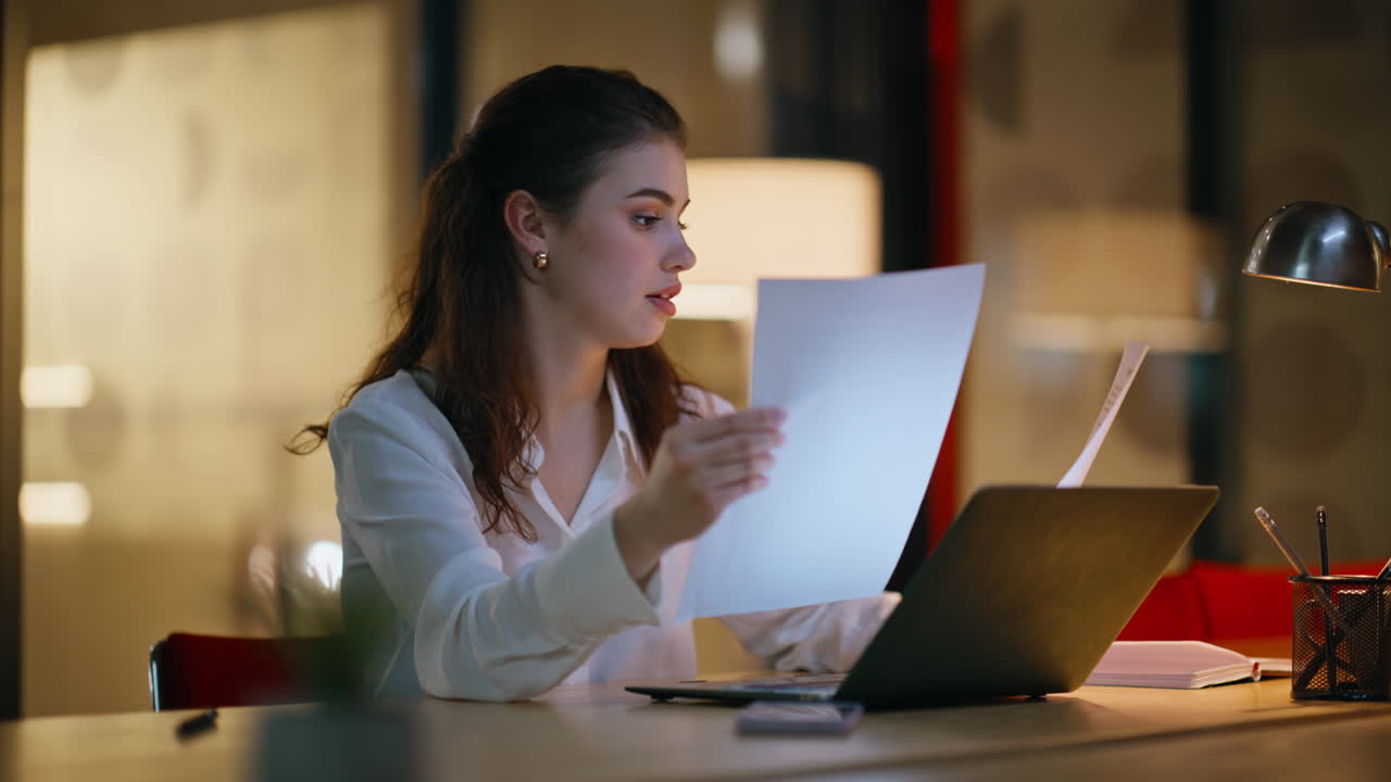 Late employee working project sitting dark workplace looking laptop closeup