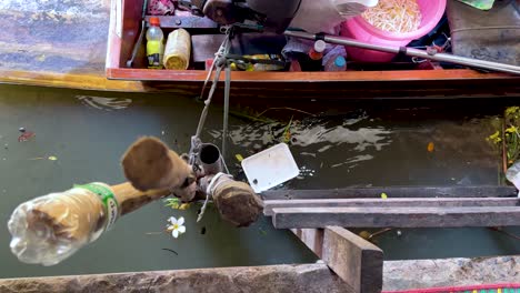 boat collecting trash in bangkok's floating market