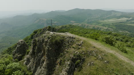 Dolly-out-shot-revealing-a-Christian-cross-against-a-foggy,-calm-landscape