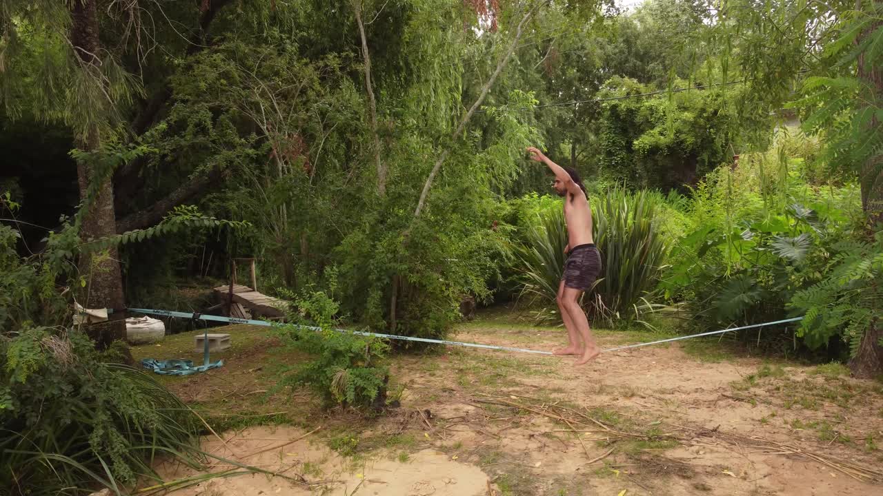 joven balanceándose en una línea floja en la jungla, delta del paraná, argentina