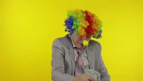 Elderly-clown-businessman-entrepreneur-boss-dancing,-entertains,-receive-money