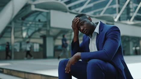 stressed businessman sitting outdoors in a city