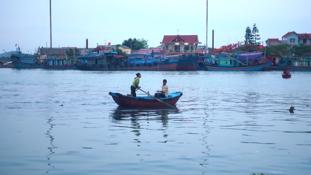 작은 베트남 어촌 마을의 로우보트에 있는 두 사람의 와이드쇼트