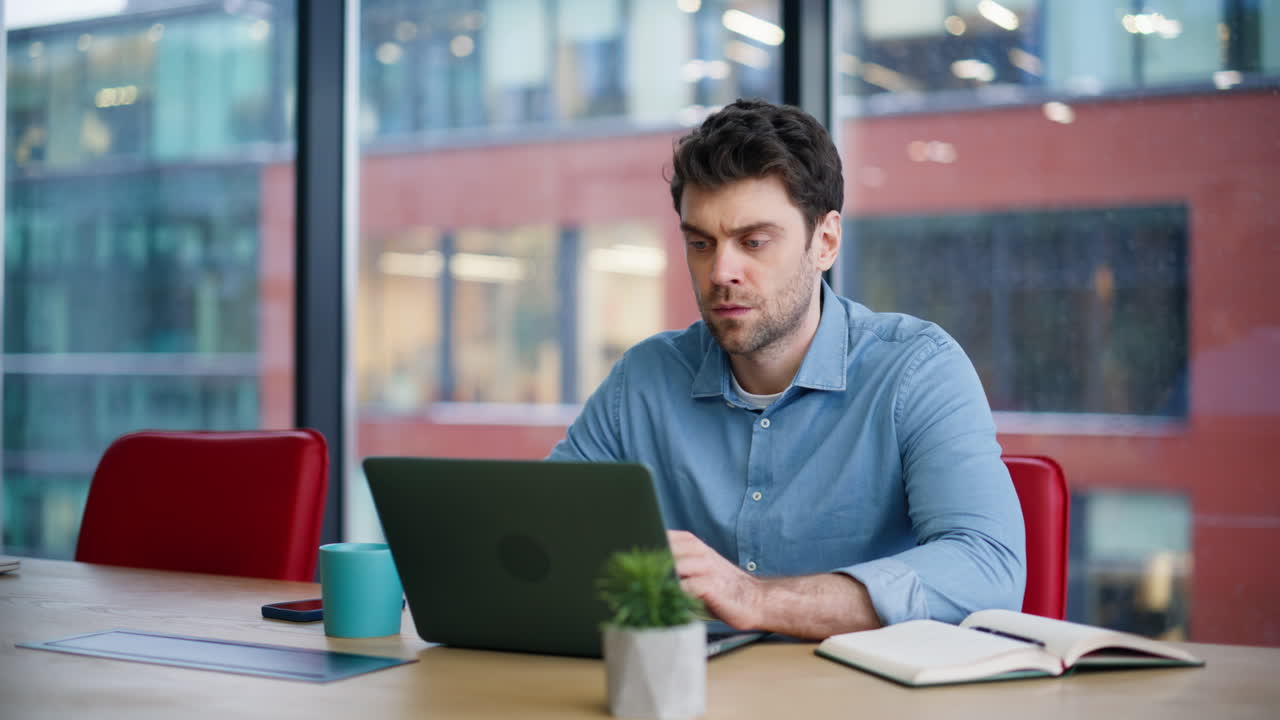 Focused manager surfing internet at laptop sitting office closeup. Serious man