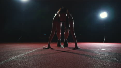 athlete woman in black shorts and a t-shirt in sneakers are in the running pads on the track of the sports complex and run in slow motion