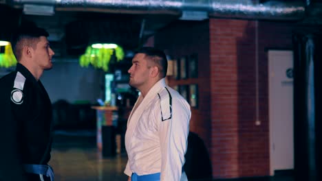 los luchadores de jtujitsu serios van a encontrarse entre sí, una mirada seria al enemigo antes de la batalla. movimiento circular de la cámara.