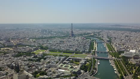 Beautiful-elevated-panoramic-footage-of-large-city-with-tourist-landmarks-near-Seine-river.-Gardens-and-historic-complex-Les-Invalides-and-tall-Eiffel-Tower.-Paris,-France
