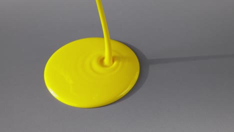 yellow paint droplet on gray surface