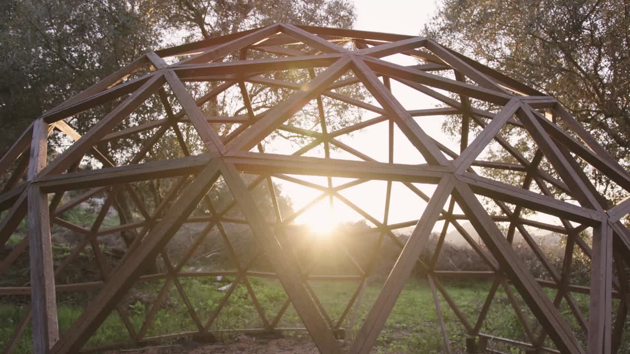 Mid shot of wooden hexagonal geodome structure outdoors