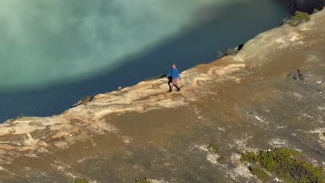 cinematic view of woman hiking along crater edge of ijen volcano, adventure female